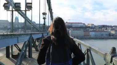 120 fps yavaş çekimde Avrupa 'yı ziyaret eden bir turist kızın sırtı köprüde yürüyor.