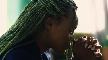 Ruhani Afrikalı Amerikalı Tanrı 'ya dua ediyor. Dini bütün Latin kökenli yetişkin bir kız. Dua profilinde, yakın plan yüzü var. İlahiyete tapan kişi