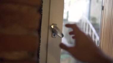 Ev penceresini açan kişi. Kapalı el düğmeyi açar