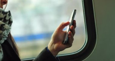 Cep telefonunun yakın plan çekimi e-postaları kontrol etmek ve hareket halindeki bir trende gidip gelirken internette sörf yapmak. 