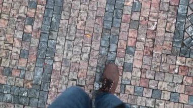 Çamurlu bir ortaçağ toprağında yürüyen çizme giyen biri. Yaya yürüyüşüne bakış açısı