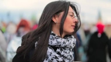 Kadın kalabalığın ortasında saçını tarıyor. Saçıyla saçını düzenleyen kızın gerçek bir klipsi.