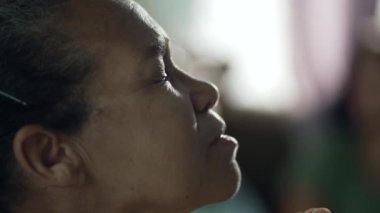 Meditasyon yapan son sınıf öğrencisi kadın tefekkür yaparken gözlerini kapatıyor. Meditasyondaki ruhani yaşlı kadın. Profil, Güney Amerikalı bir kadının gözlerini açtığını gösteriyor.