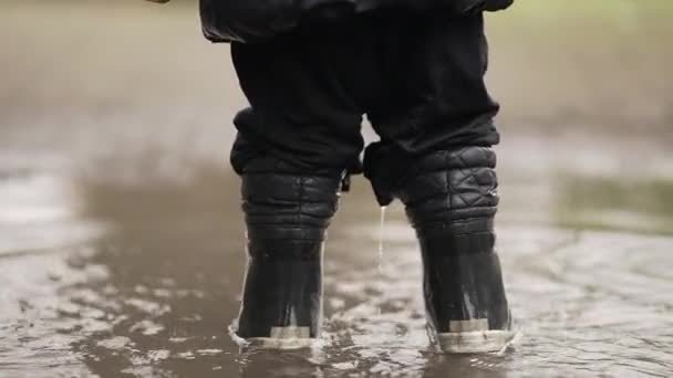 Kind Spielt Regenstiefeln Mit Pfütze — Stockvideo