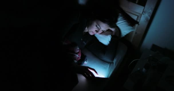 スマート フォンでベッドで若い女性 寝る前に携帯電話のデバイスで主演の女性 — ストック動画