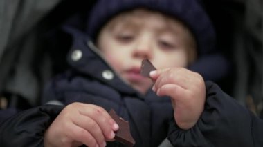 Küçük çocuk çikolata yiyor.