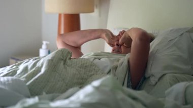 Son sınıf öğrencisi sabah uyandığında gözlerini ovuşturan yaşlı kadın ayağa kalkıyor..