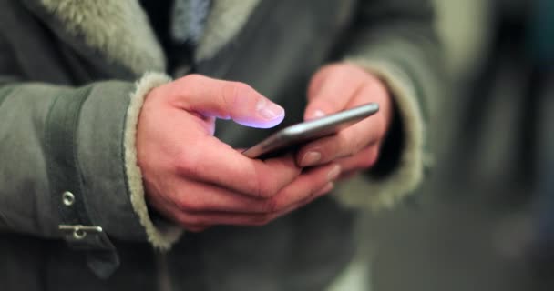 スマートフォンでインターネットを閲覧している携帯電話を持っている通信者が友人にメールをチェックしながら 4Kの地下鉄プラットフォーム上で — ストック動画