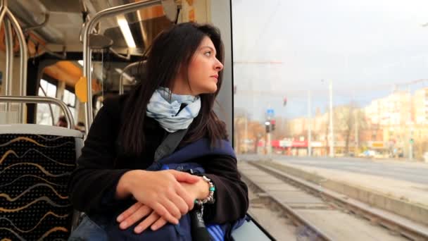路面電車に乗っている観光客の女の子は窓の外を見る 近代的な交通機関に乗っている間 女性は街の風景を見る — ストック動画