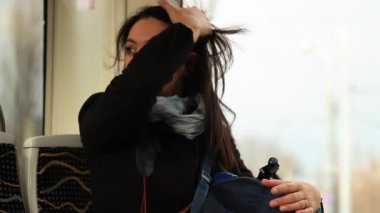 Tramvaya binen kadın pencereden dışarı bakıyor. Banliyö ya da turist kız metro vagonuna biner ve manzaraya bakar.