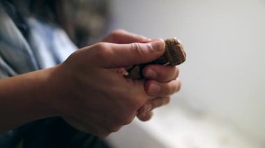 Şampanya şişesini açmaya çalışan bir kadın, izleyiciler şampanyayı itmeye çalışırken heyecanla bekliyor.