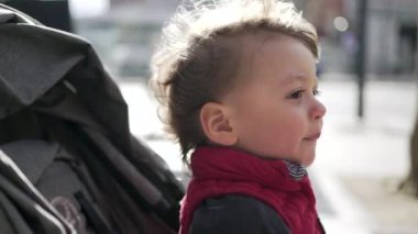 Küçük çocuk şehirde geziniyor Rüzgarı hissediyor