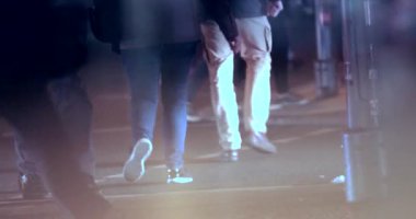4K 'de kalabalık bir cadde. Yansıtıcı pencereden görünen bacaklar ve ayaklar