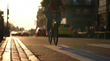 Gün batımında sokakta bisiklete binen biri. Bisiklete binen adam