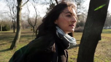 Soğuk mevsimde ve günbatımı lenslerinde parkta ağır çekimde yürüyen bir kadın.