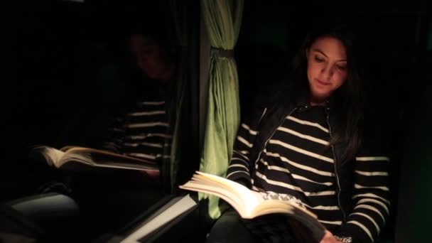 Kobieta Czyta Książkę Siedząc Autobusie Podróżując Nocą — Wideo stockowe
