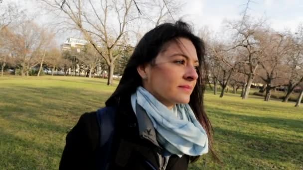 寒い季節にはゆっくりと公園を歩く女性 歩いている間に女の子の髪に吹く風 — ストック動画