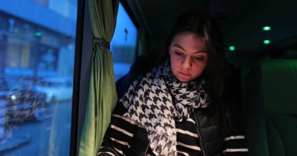 晚上乘公共汽车旅行时 女乘客在看书 女孩坐在靠窗的移动车辆上看书 — 图库视频影像