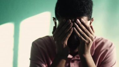 Depresyondaki genç adam yüzünü eliyle kapatıyor ve ANXIETY hissediyor. TRAUMA 'yı hatırlayan olumsuz duyguları olan acı çeken kişi.