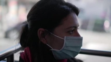 Otobüse binen yüzü maskeli bir kadın.