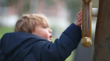 Küçük çocuk parkta ahşap direksiyona dönüyor. çocuk nesneyle oynar