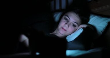 Genç kadın ile smartphone yatakta. Yatmadan önce cep telefonu cihaz oynadığı kadın 
