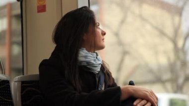 Hareket halindeki tramvayda pencereden dışarı bakan düşünceli kadın. Düşünceli kız pencereden dışarı bakar ve hayatı düşünür.