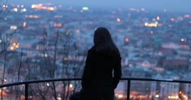 Gece şehir manzarasına bakan bir kadın. Düşünceli düşünceli kız gece Budapeşte şehri manzarasını izliyor.