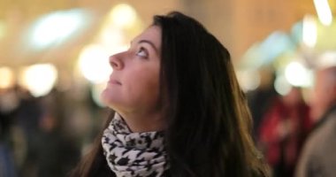 Neşeli genç bir kadın yukarı bakıyor. Kız düşünceli ve düşünceli.