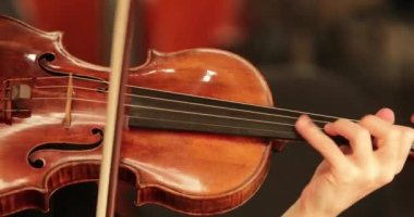 Kemancı konser salonunda keman çalıyor. Müzisyen 4K senfoni orkestrasında çalıyor.