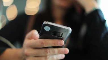 Akıllı telefon cihazına bakan kadının yakın çekimi