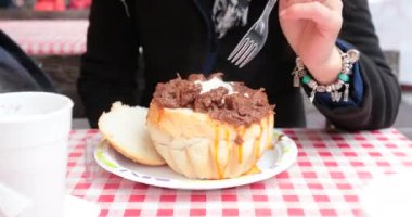 Budapeşte 'deki yıllık Noel pazarında ekmek kasesinde Gulaş yiyen turist kadın.