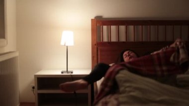 Kadın gece yarısı uyanıyor, uyuyamıyor, dinlenmekten yoksun. İnsan uyanır ve yataktan kalkar.