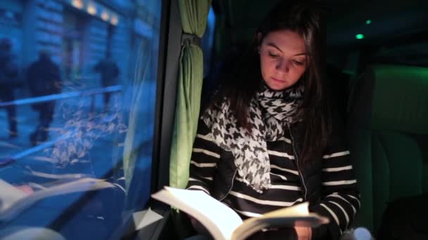 Akşamları Otobüsle Seyahat Eden Bir Kadın Hareket Halindeyken Kitap Okuyan — Stok video