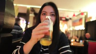 Kadın lokantada bira içiyor. 