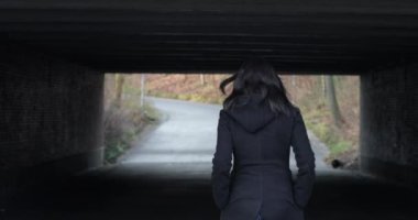 4K 'de bir köprünün altında yürüyen kadın silueti. Yalnız melankolik, hüzünlü bir atmosfer Kader yolculuğu konsepti