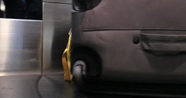 Uluslararası havaalanında bagaj teslim. İnsanlar bavullarını ve çantalarını 4K taşıyıcısından alıyor.