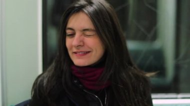 Metro trenine binerken bir kadın kameraya göz kırpıyor. Kız izleyiciyle flört eden seyirciye göz kırpıyor