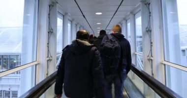 Koridorda yürüyen insanlar uçağa biniyor ya da çıkıyorlar.