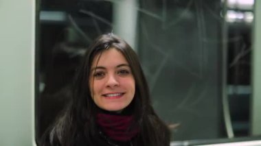 Metro trenine binerken bir kadın kameraya göz kırpıyor. Kız izleyiciyle flört eden seyirciye göz kırpıyor