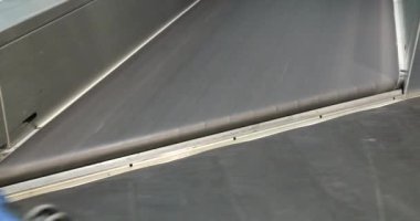 Uluslararası havaalanında bagaj teslim. İnsanlar bavullarını ve çantalarını 4K taşıyıcısından alıyor.