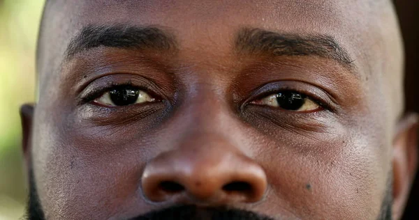 African man eyes close-up face looking at camera, macro closeup