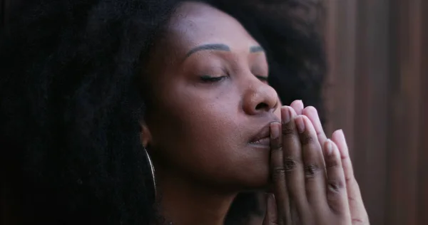 Hopeful African woman praying to God seeking FAITH and HOPE