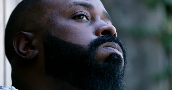 Upset man, worried African person feeling stress and anxiety close-up face