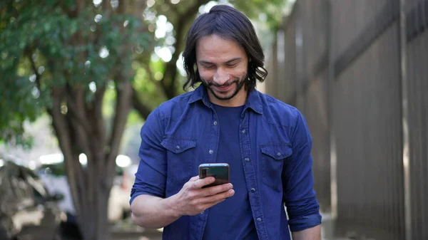 Casual Joyful South American Man Checking Smartphone Walking City Street — 스톡 사진