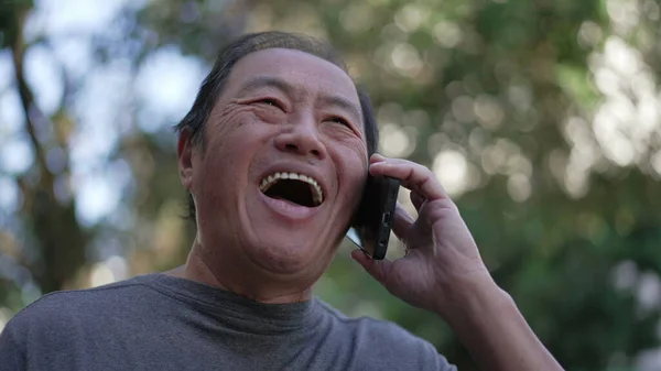Happy Senior Asian Man Speaking Phone While Walking City Street — Zdjęcie stockowe