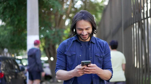 Casual Joyful South American Man Checking Smartphone Walking City Street — 스톡 사진