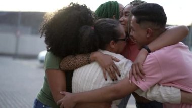 Siyah bir aile kucaklaşması. Güney Amerikalı bir grup Latin Amerikalı açık havada birbirlerine sarılıyorlar. Kucaklaşan mutlu arkadaşların portresi. Arkadaşlık kavramı