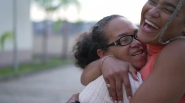 Brezilyalı yetişkin kız, büyük anneye sarılıp sevgi ve şefkat gösteriyor. Yaşlı bir bayanı kucaklayan şefkatli siyah bir kadın.