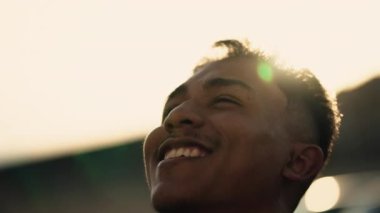 Ruhsal genç İspanyol açık havada gökyüzüne bakıp gülümsüyor. Brezilyalı bir Güney Amerikalı 'nın yakın plan yüzü. İnançlı ve umutlu.